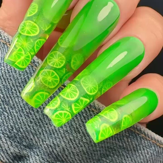 Video of green nail art with lime pattern on a denim background