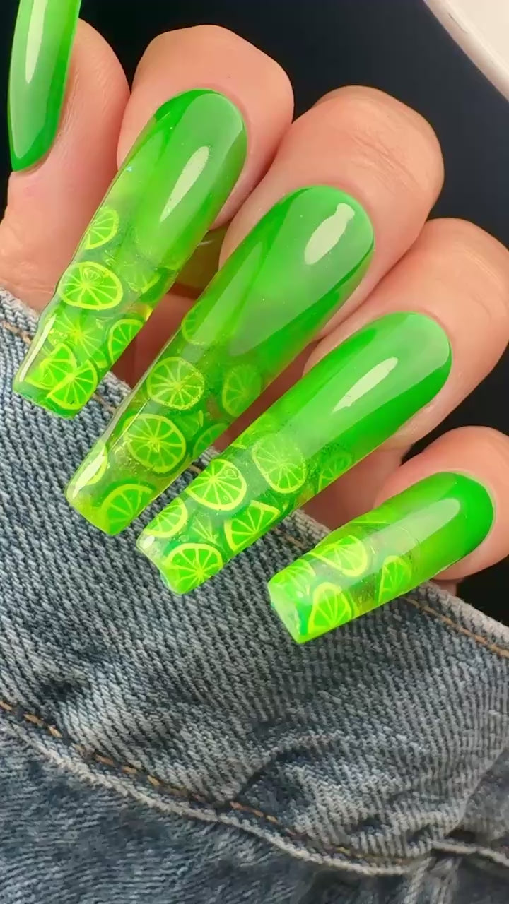 Video of green nail art with lime pattern on a denim background
