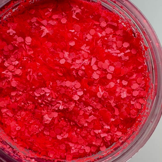 Video of hand in pink glove holding clear jar with textured glitter.
