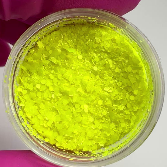 Video of hand in pink glove holding clear jar with textured glitter.