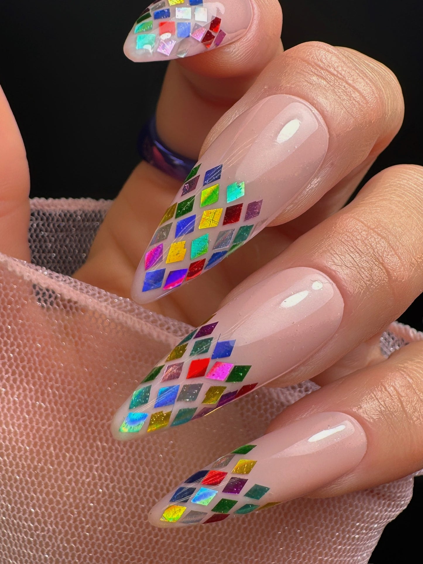 Nails with colorful diamond pattern on a plain background