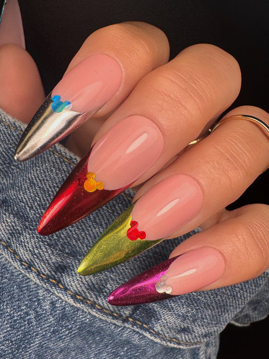 Close-up of a hand with colorful nail art against a denim background