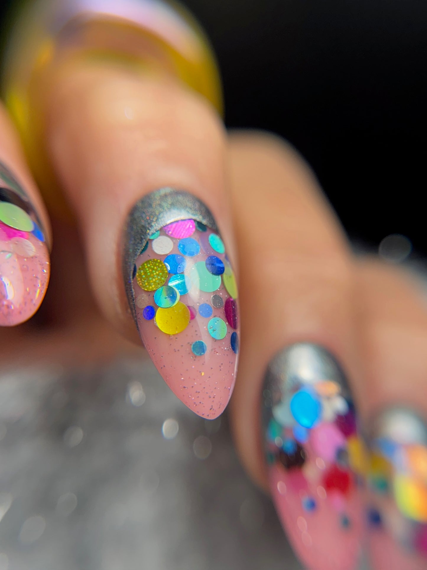 Nail art with colorful polka dots on a dark background