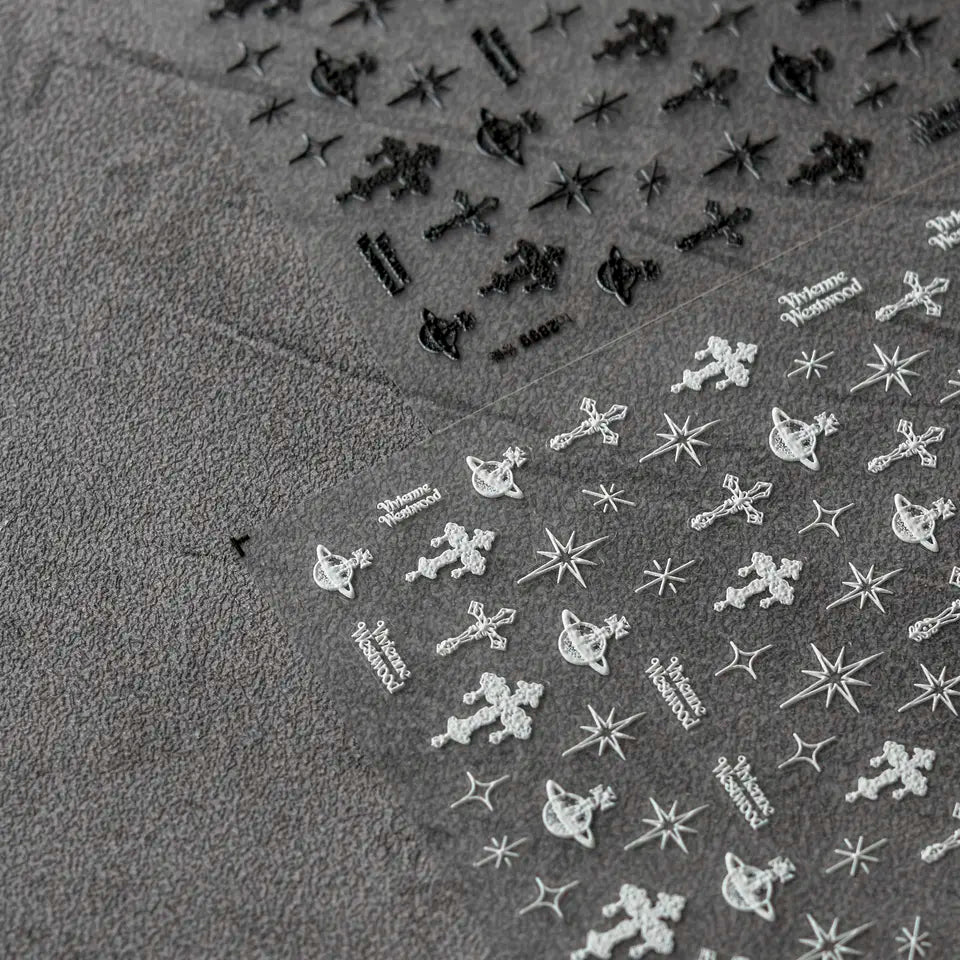 Punk Cross Nail Stickers - Textured Nail Stickers with Extravagant Cross Designs in Black and White, Displayed on a Gray Background."
