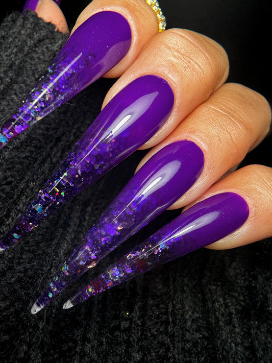 Purple glittery nails on a black textured background