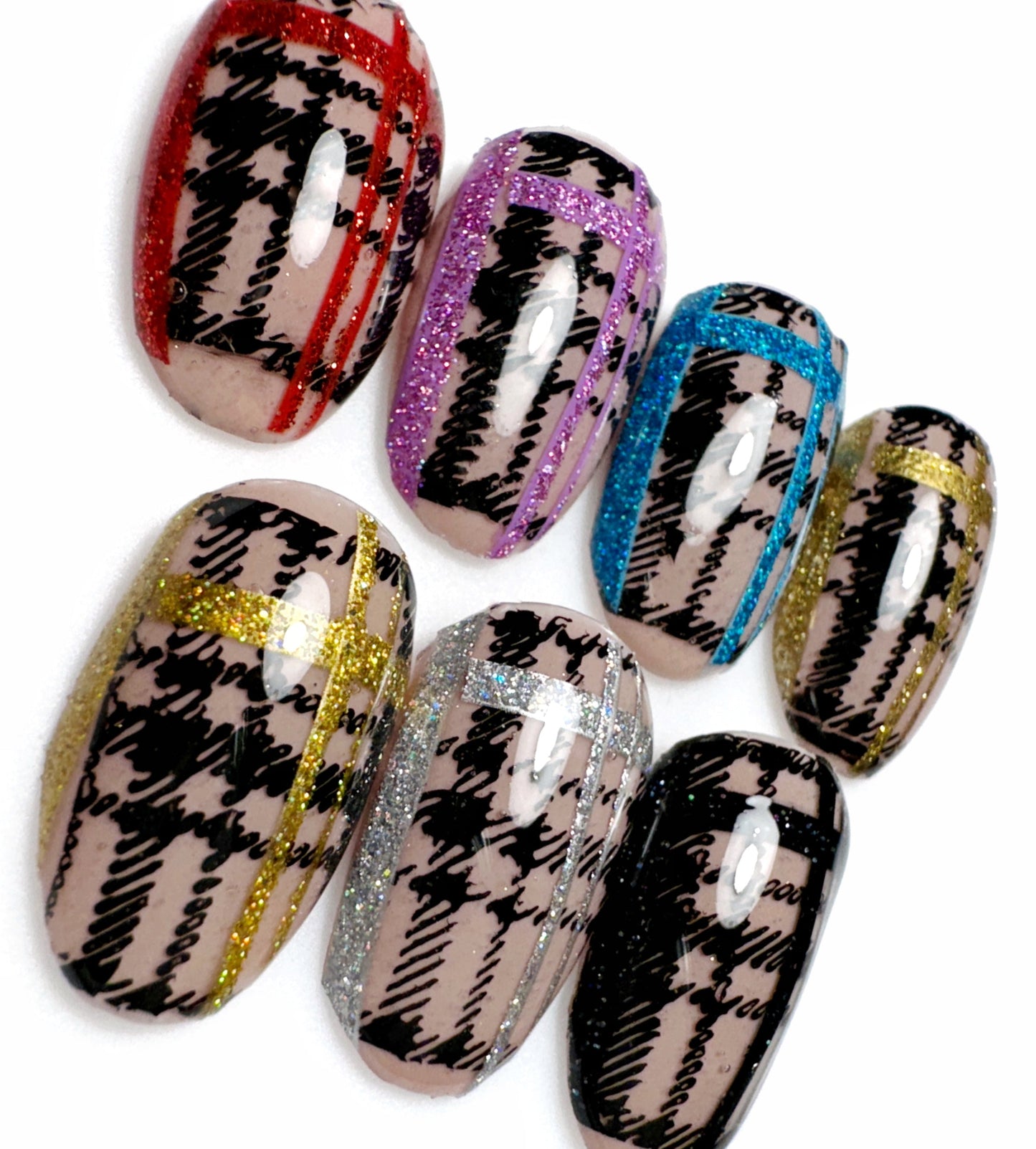 Close up view of decorated nail tips on white background.