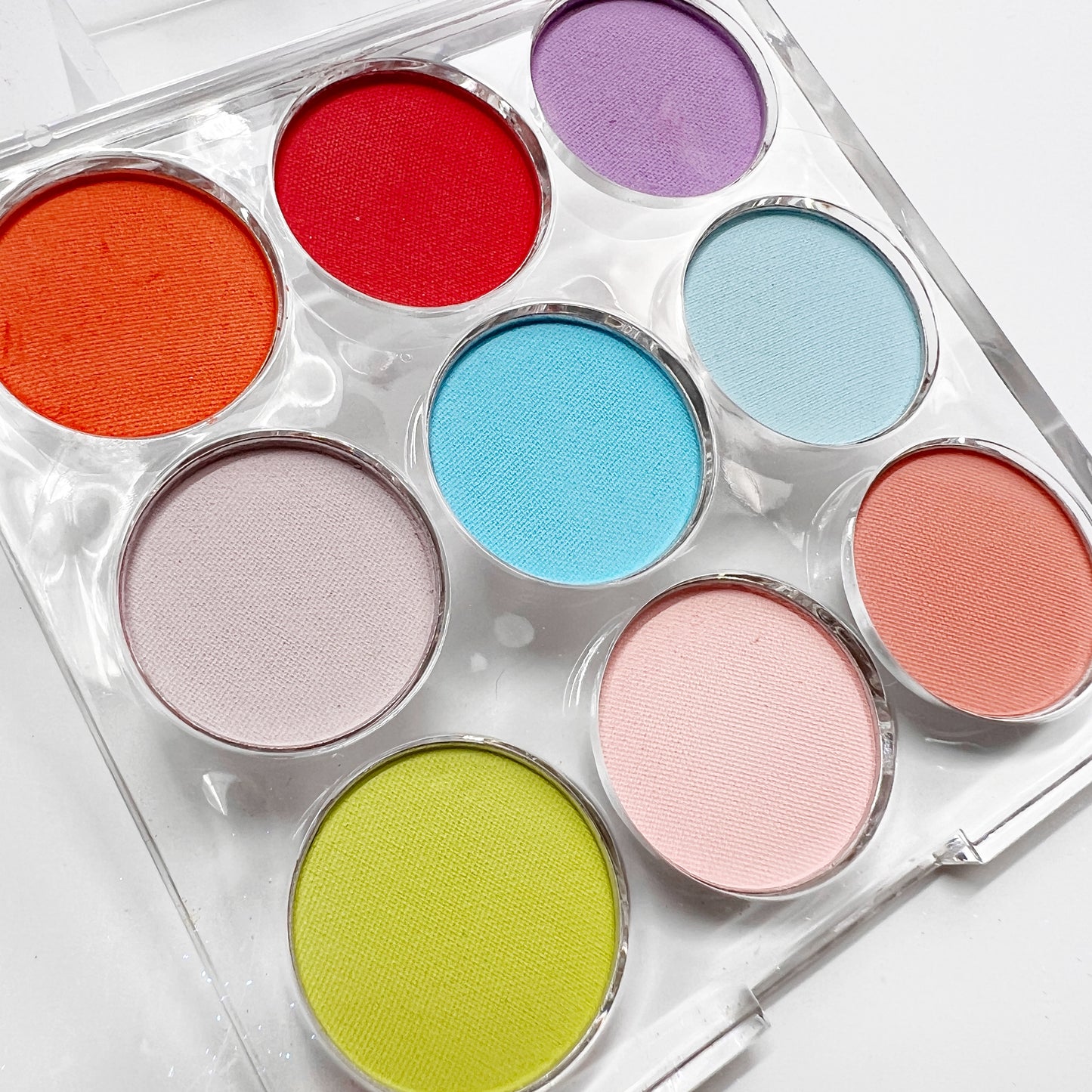 Multicolor pigment palette in clear palette on white background, 