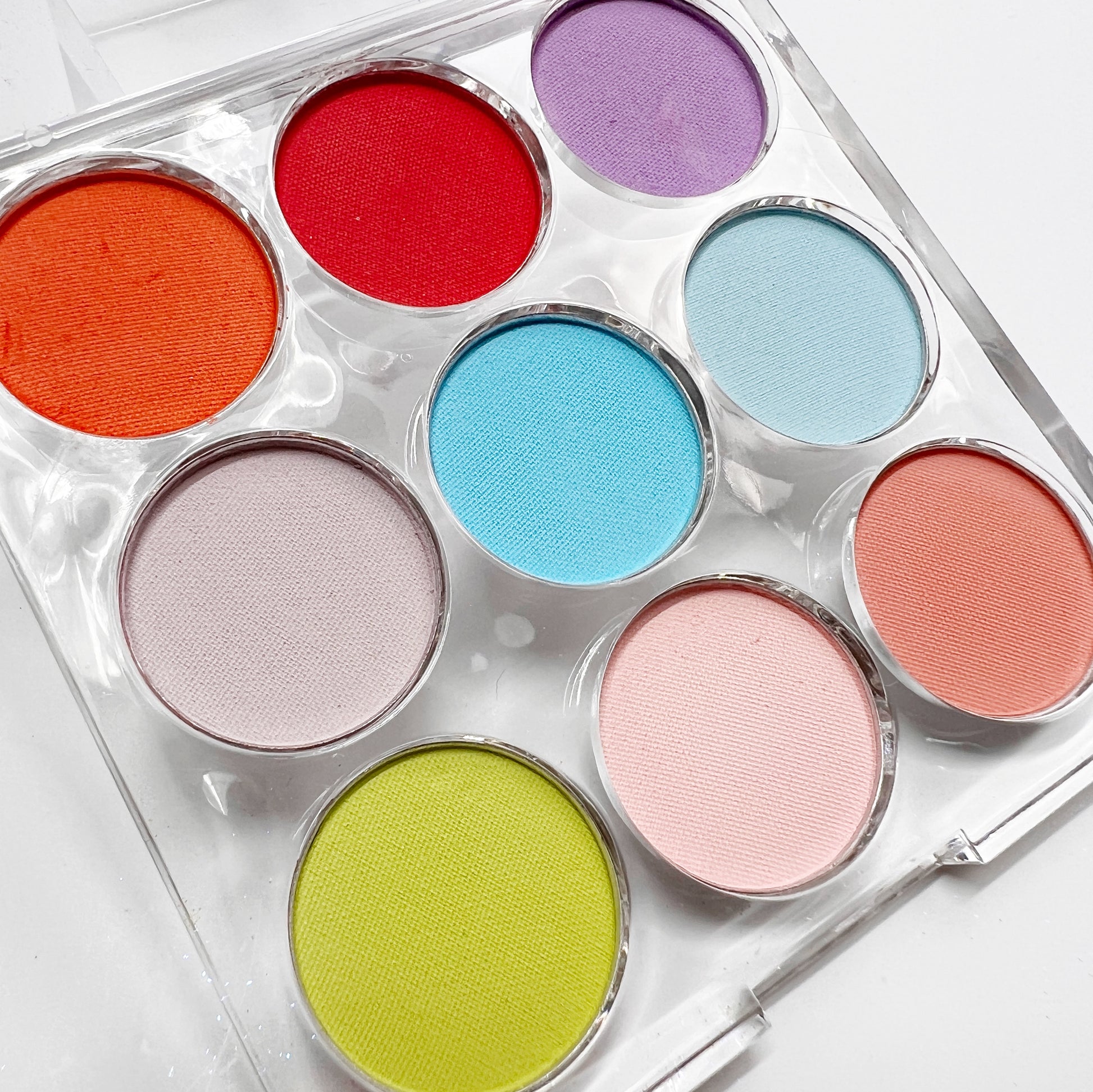 Multicolor pigment palette in clear palette on white background, 