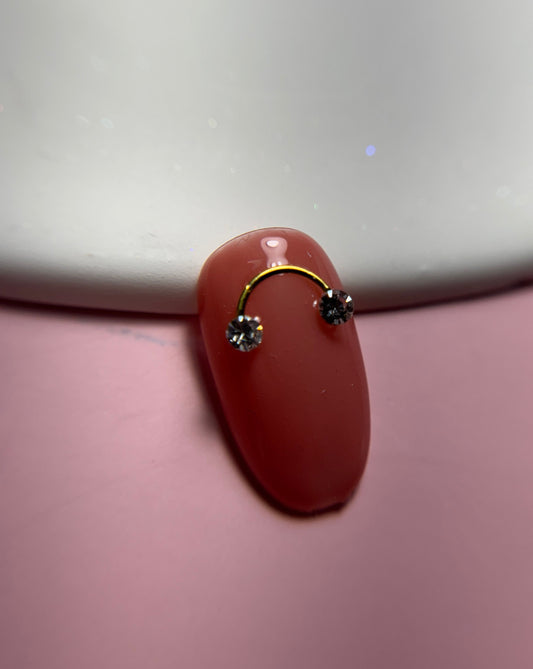 Close up of decorated nail tip on white plate and pink surface