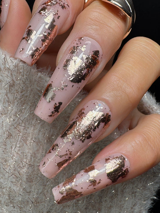 Nails with rose gold  foil design on a neutral colored nail 