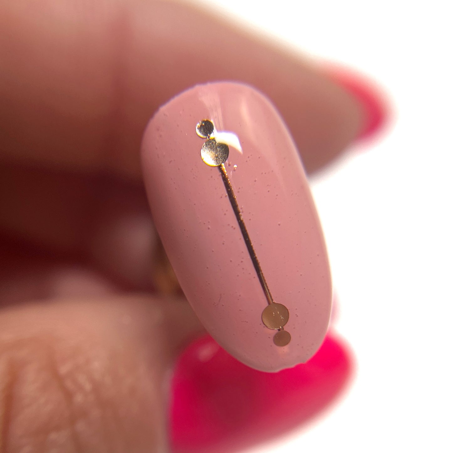 Hand holding decorated nail tip on blurred background.