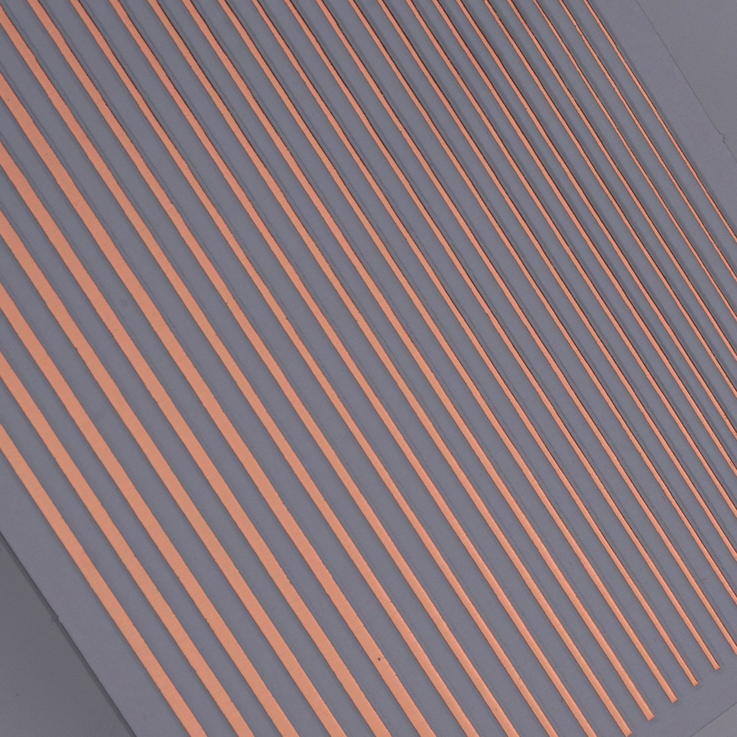 Close-up view of rose gold line nail stickers on light background.