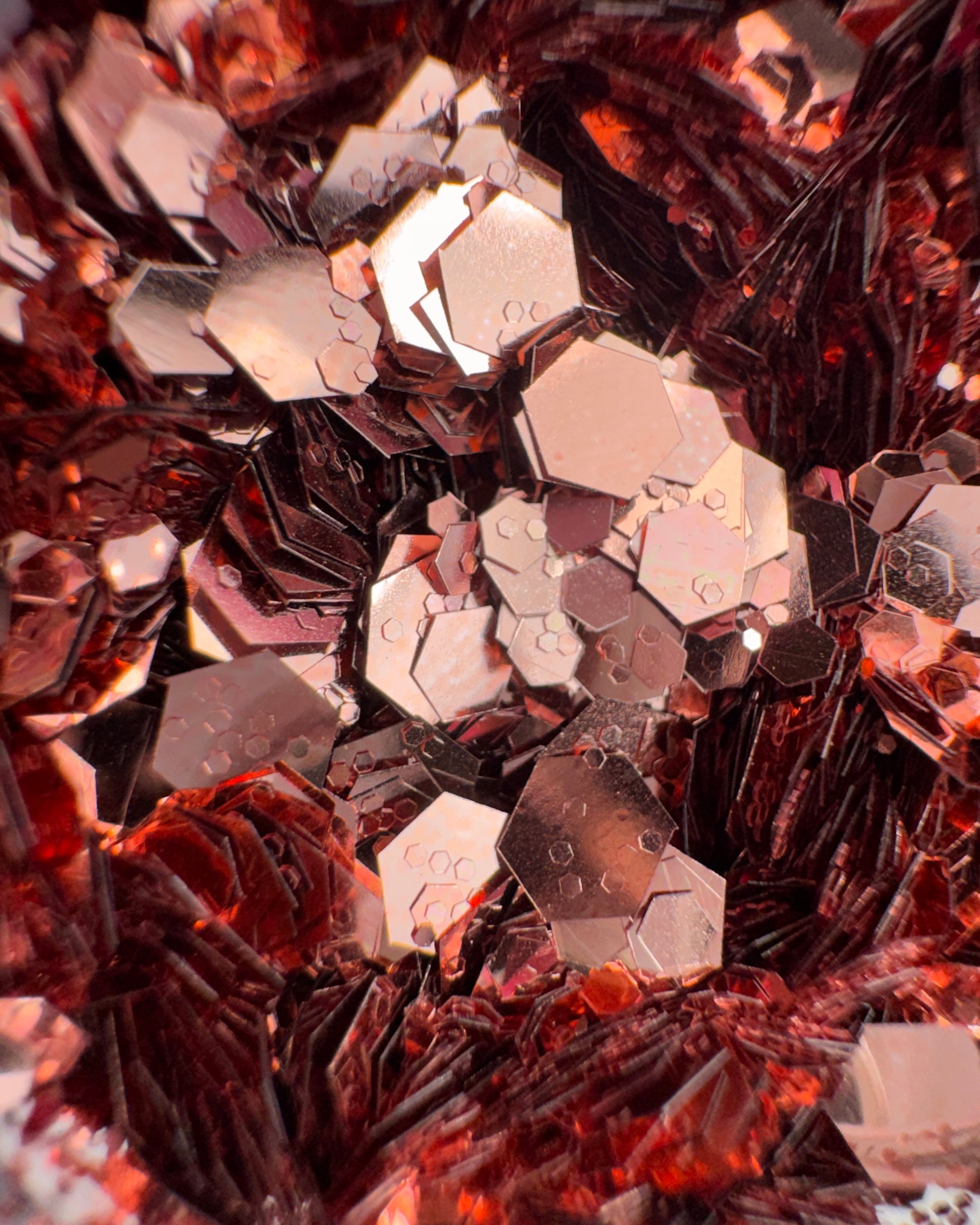Close-up of metallic hexagonal rose gold glitter mix.