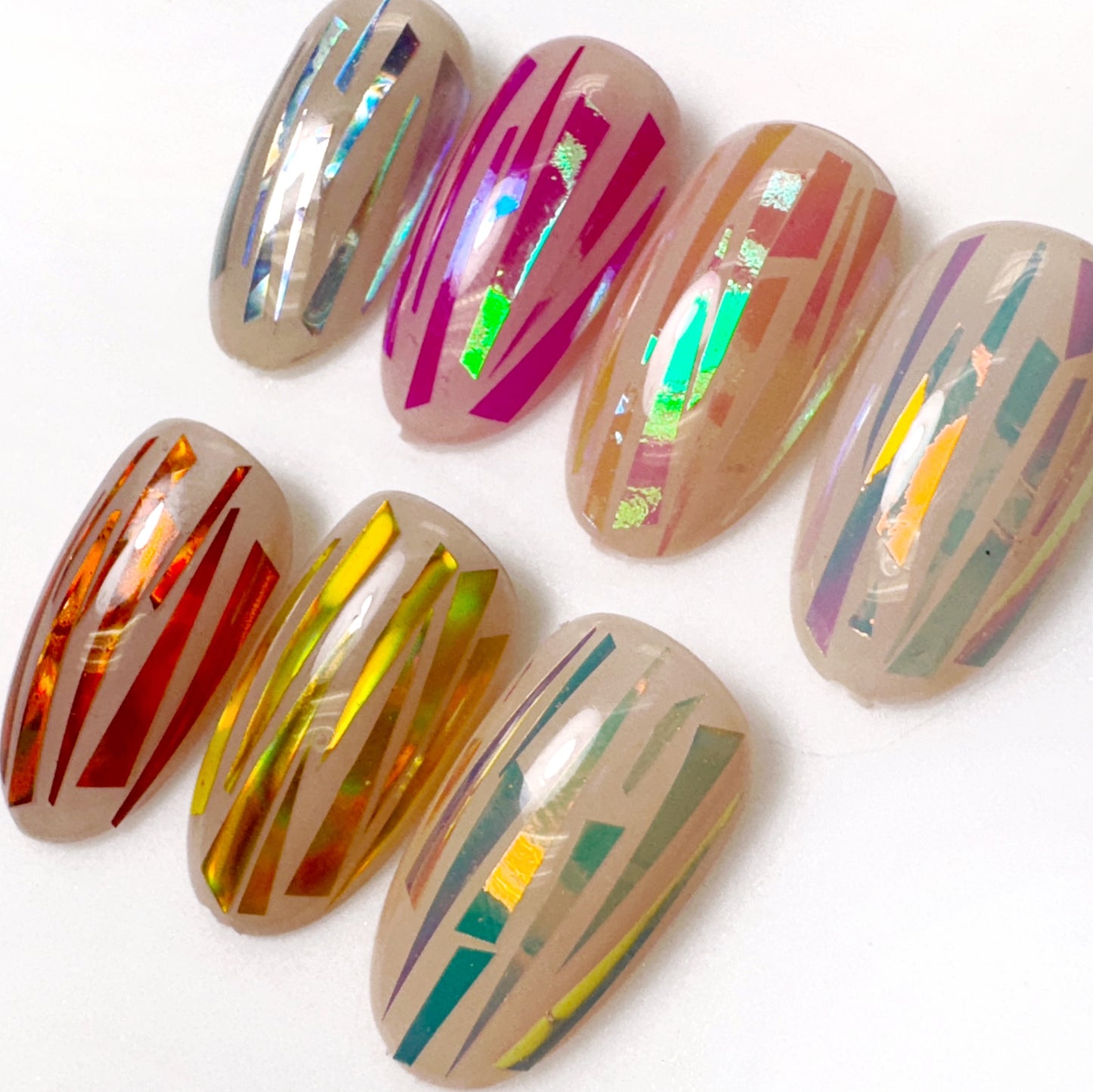 A collection of orange aurora shattered foil pieces for nail art, featuring a mix of colors and reflective surfaces.