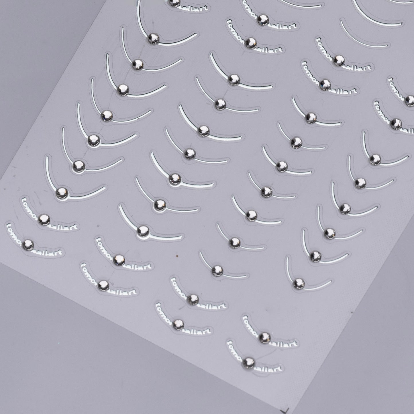 Detail view of nail decal sheet on light background.