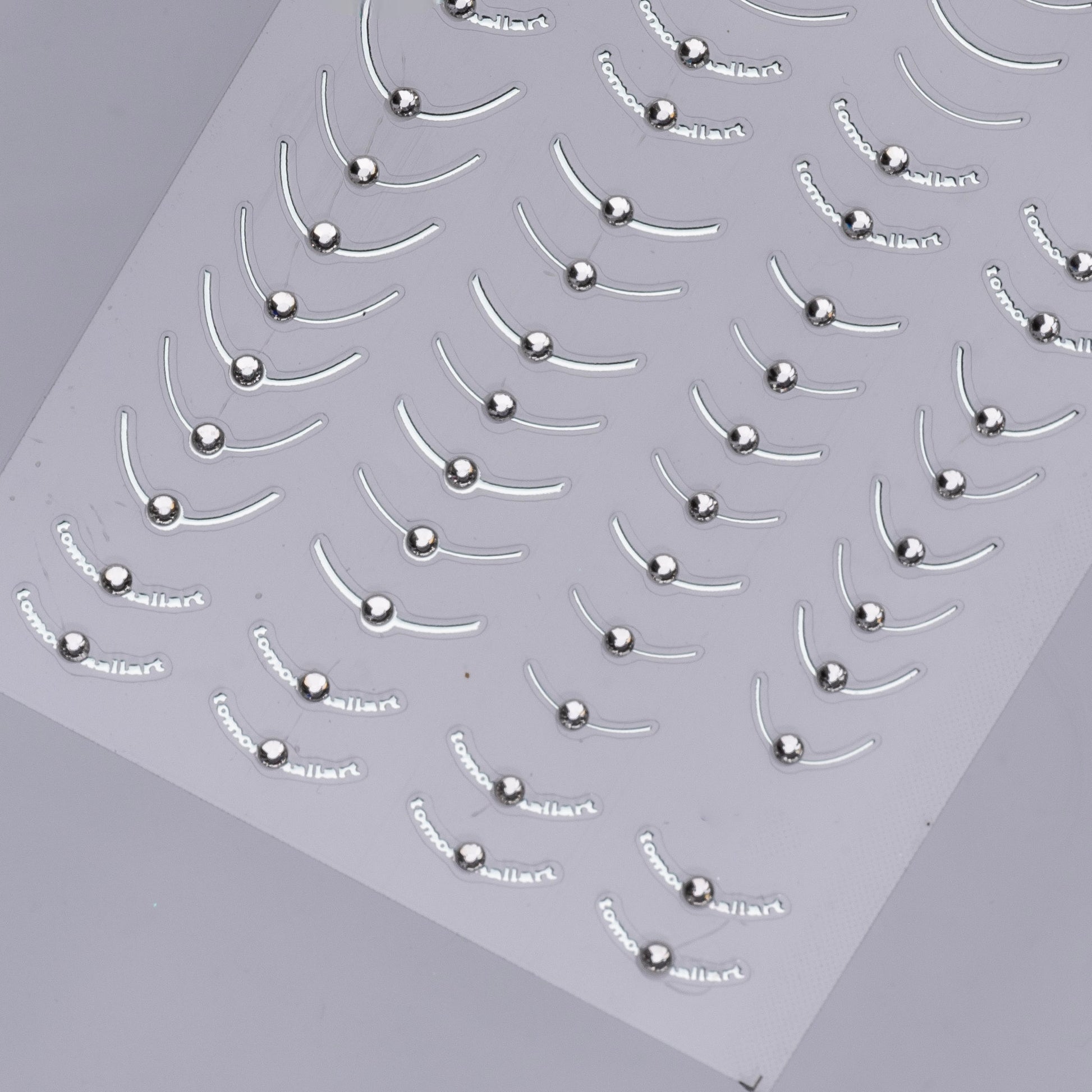 Detail view of nail decal sheet on light background.