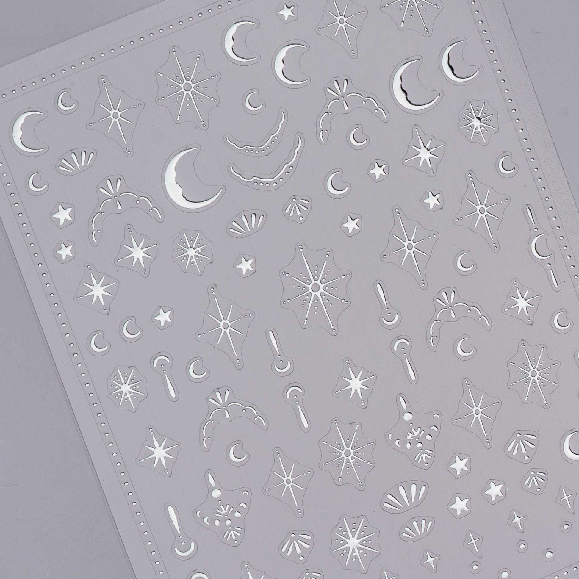 Sheet of star and moon-shaped stickers on a gray background