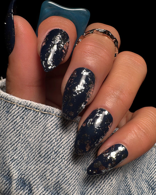 Nail art with metallic design on a denim background