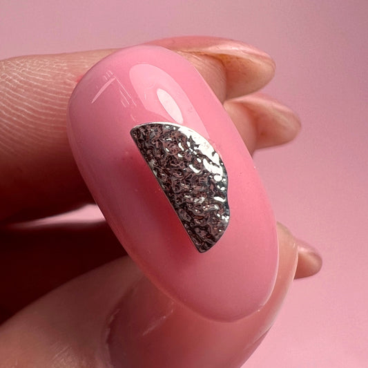 Hand holding decorated nail tip.