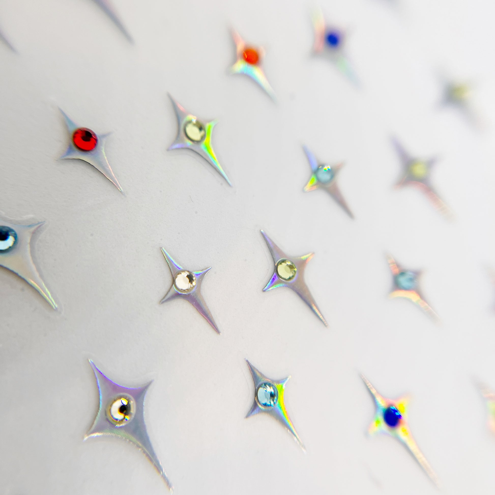 Jewel Star Nail Stickers - Four-Point Stars with Center Rhinestone Detail, Piictured in Holographic Silver with Colorful rhinestone. 