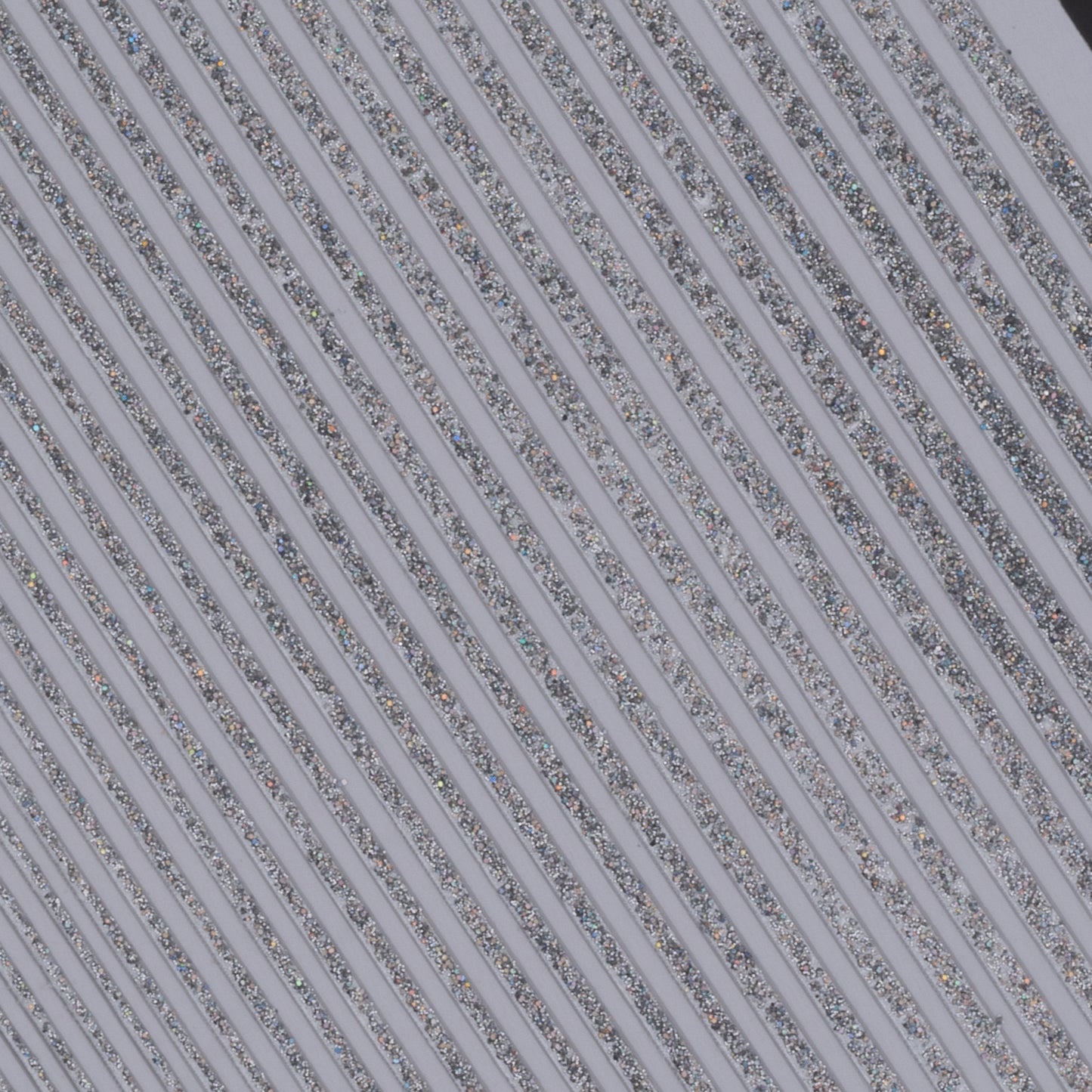 Close up view of silver glitter line nail stickers on white background.