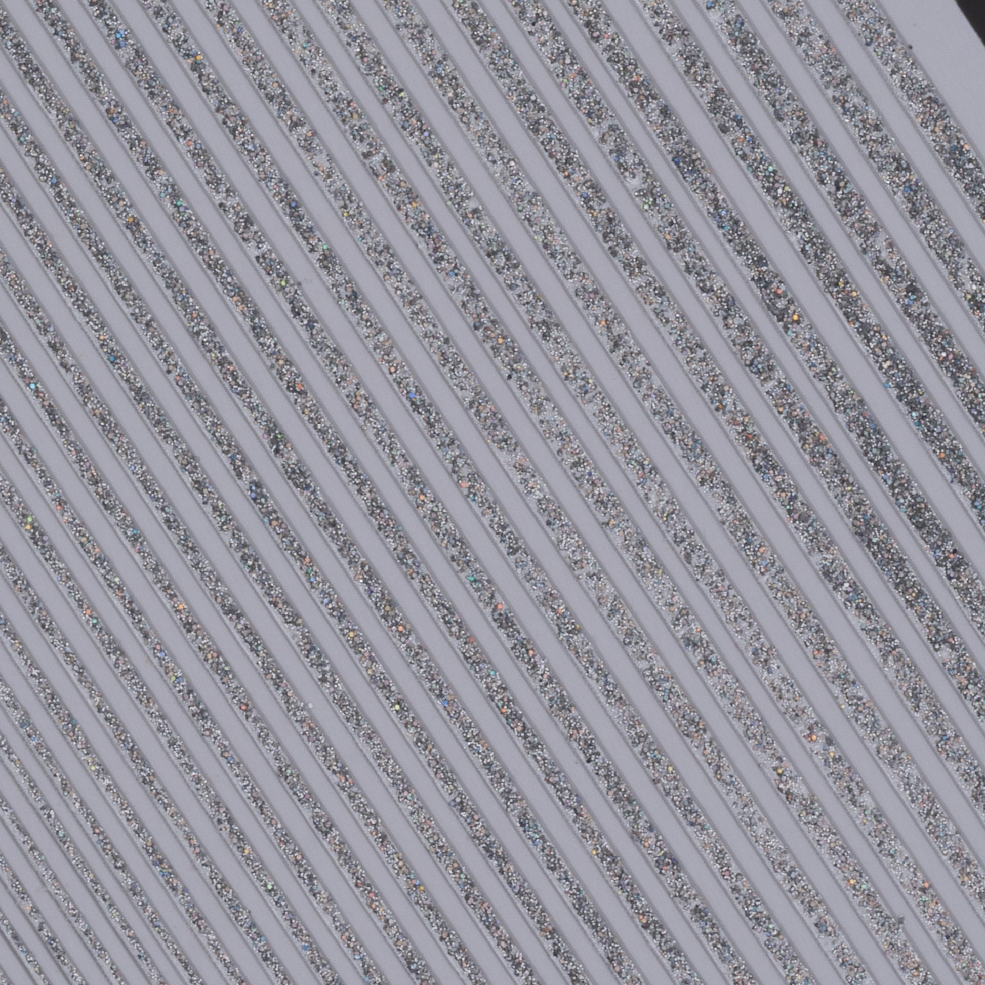 Close up view of silver glitter line nail stickers on white background.