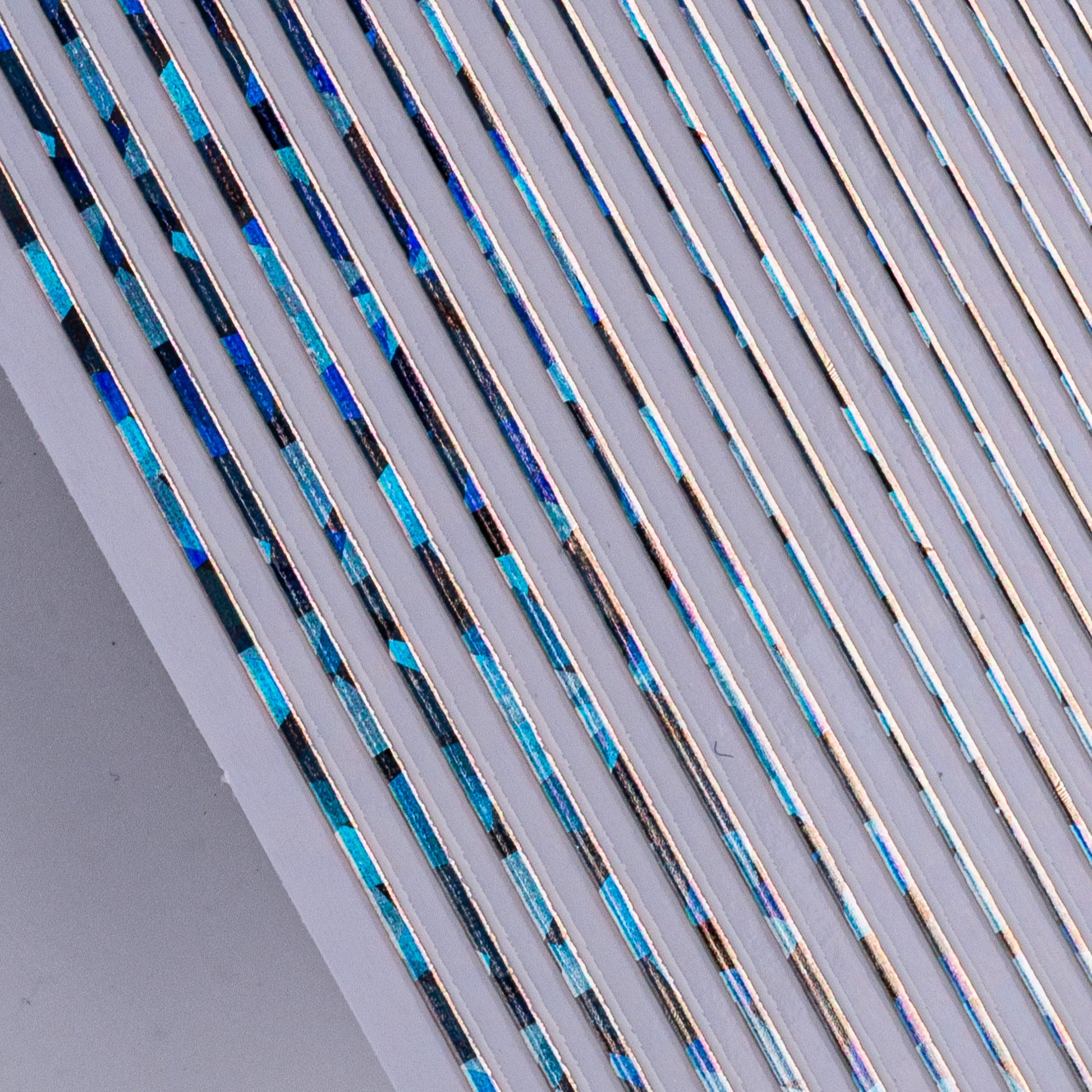 Close-up view of silver holographic nail line sticker sheet on white background.