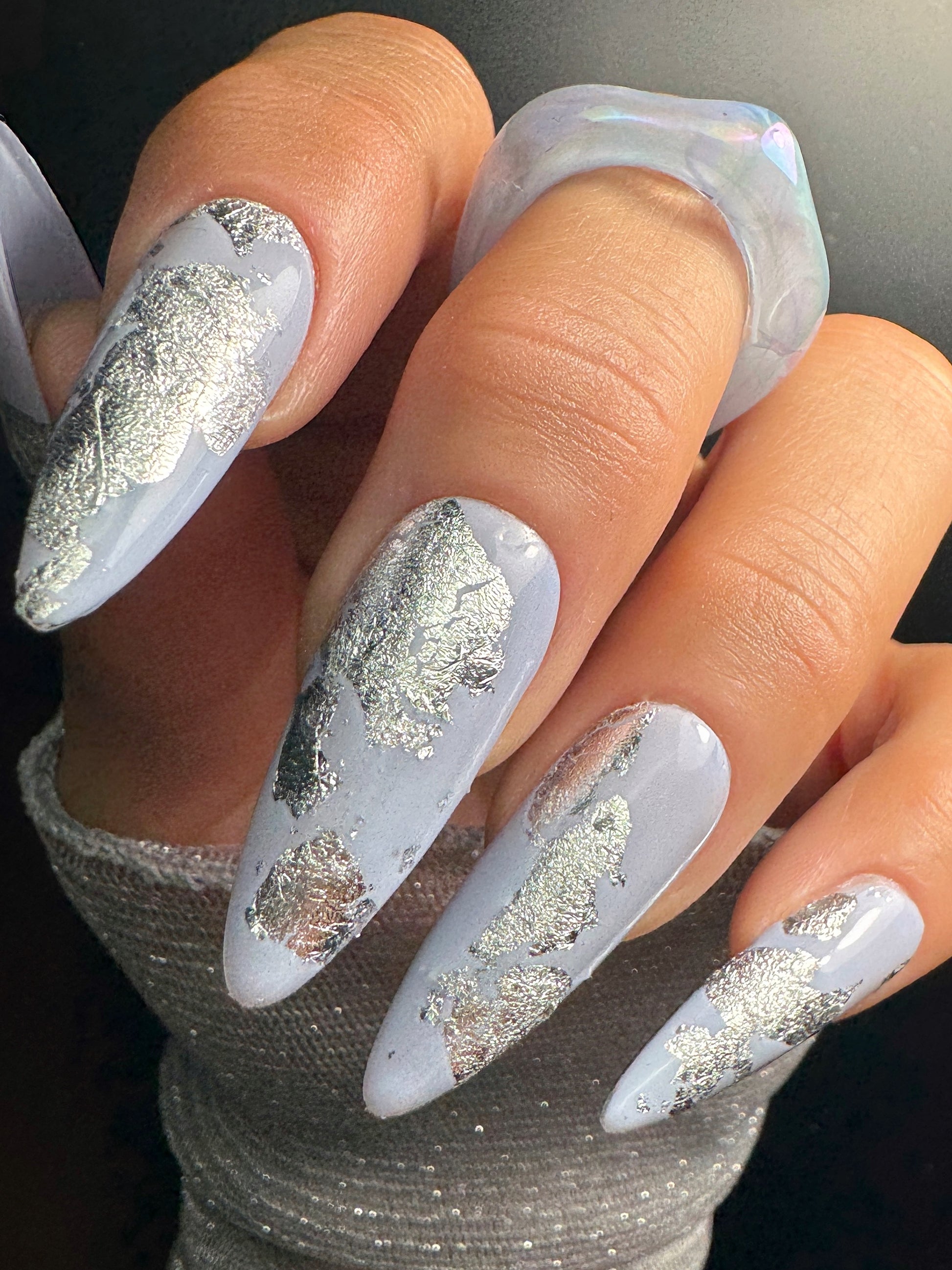 Nails with silver foil design on a neutral background