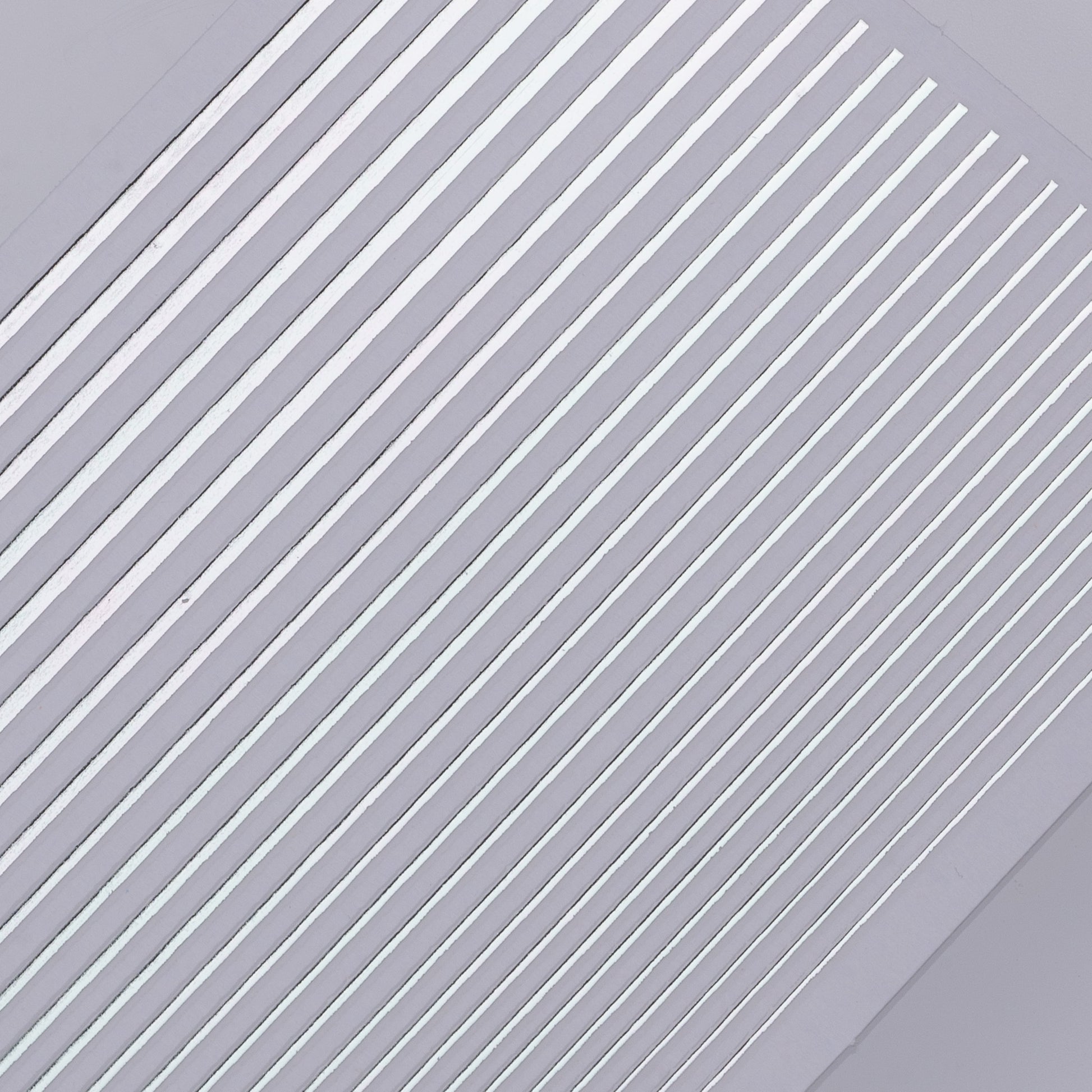 Detail view of silver line nail decal sheet on light background.