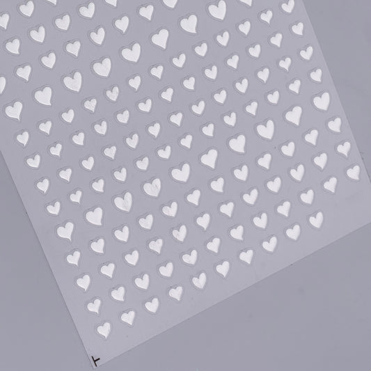 Sheet of silver heart-shaped stickers on a gray background