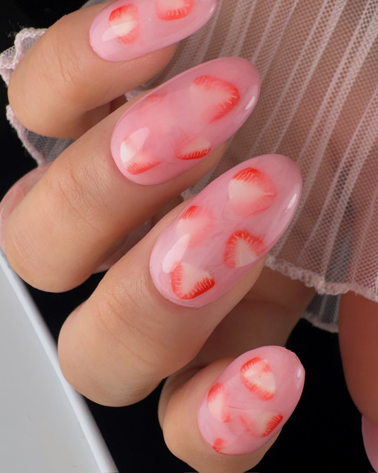 Nails with strawberry design on a black background