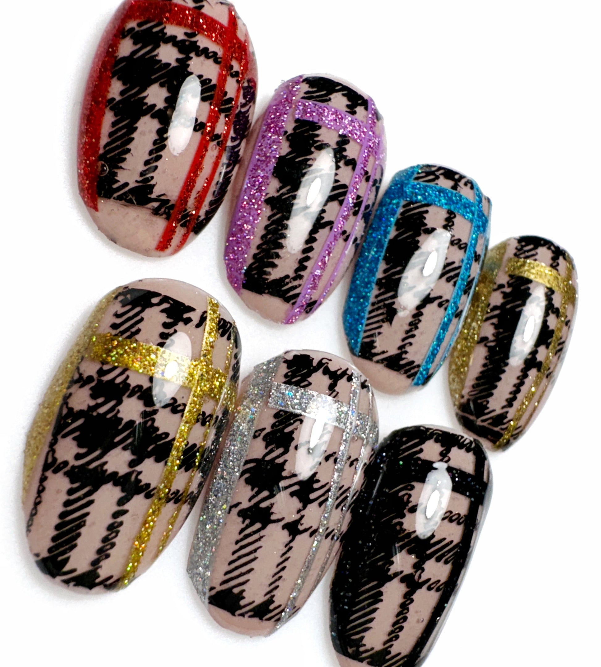 Close up view of decorated nail tips on white background.