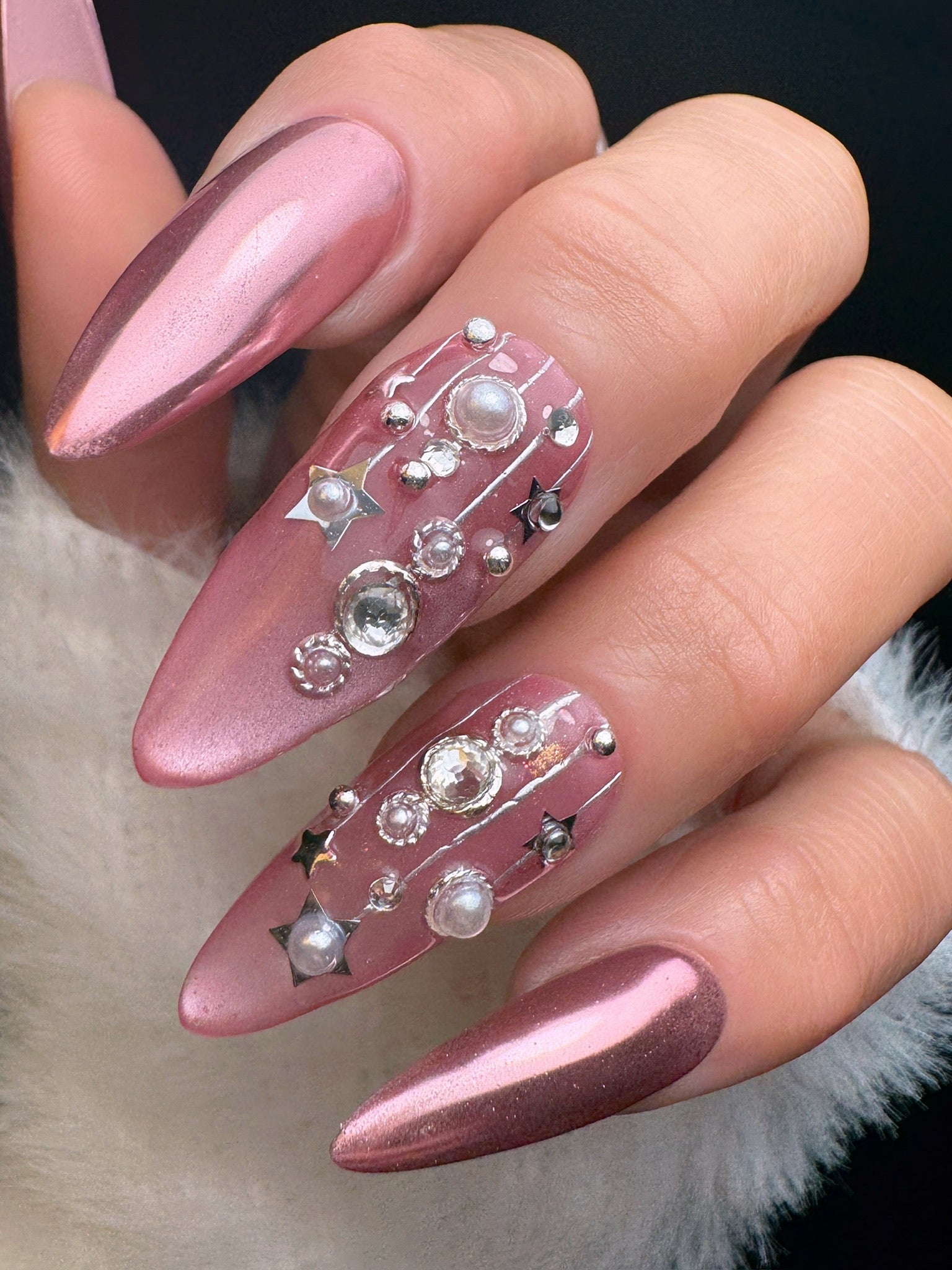 Nail art with pink and brown gradient and decorative elements on a neutral background