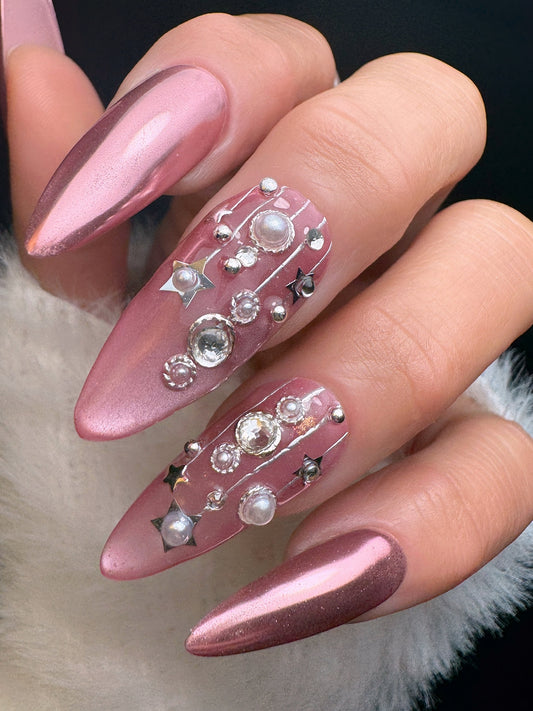 Nail art with pink and brown gradient and decorative elements on a neutral background