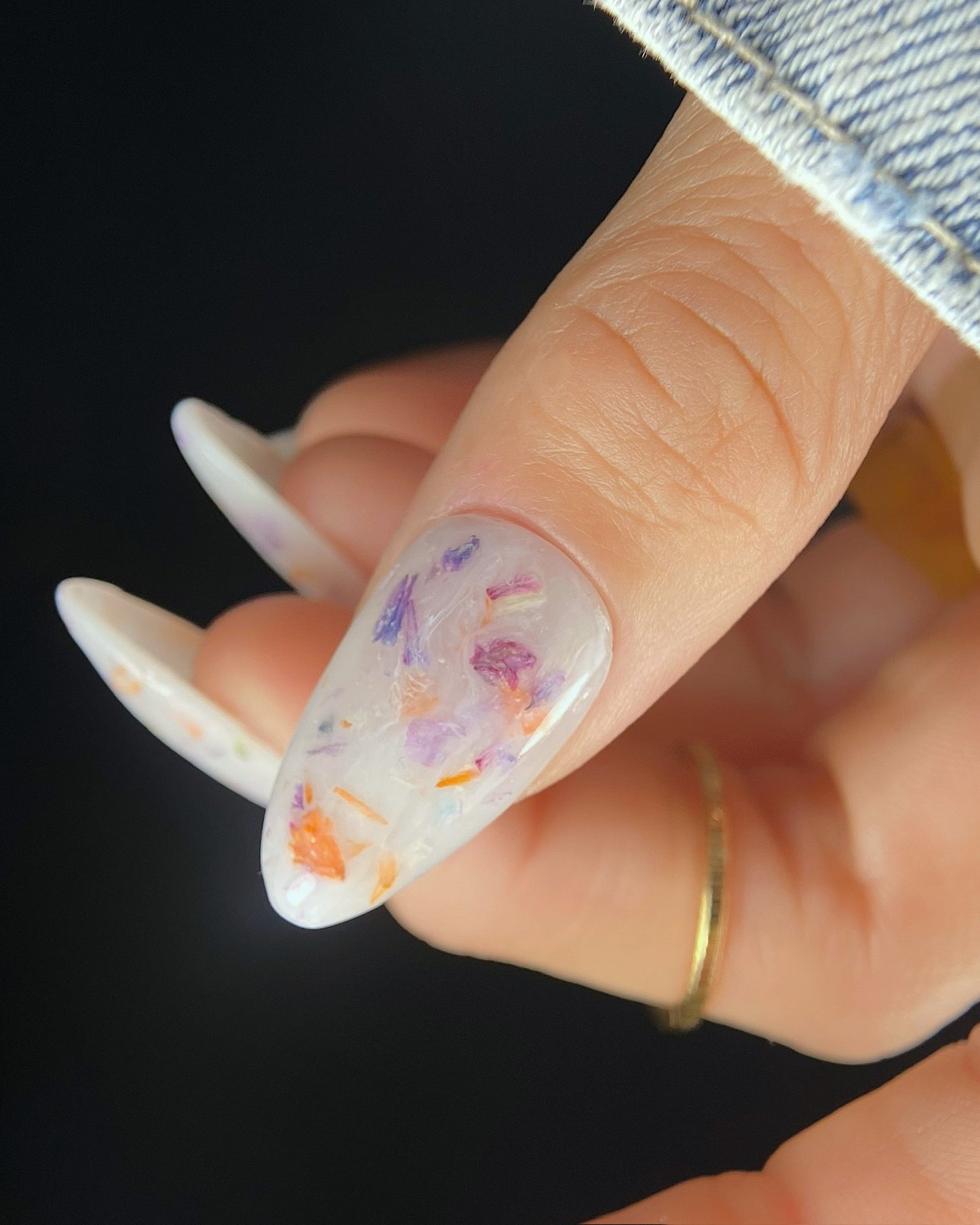 Close up of thumb with floral nail art.