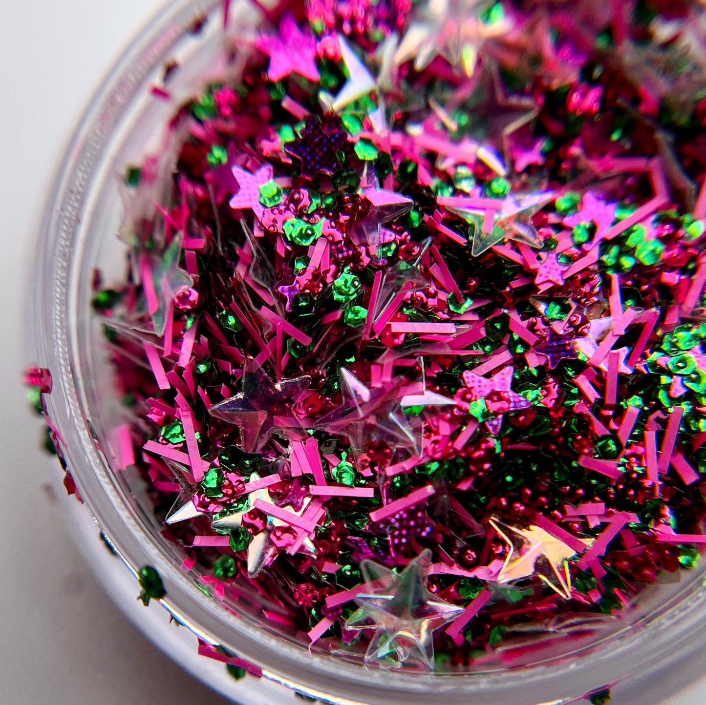 A close-up of multicolored nail glitter with star shapes visible.