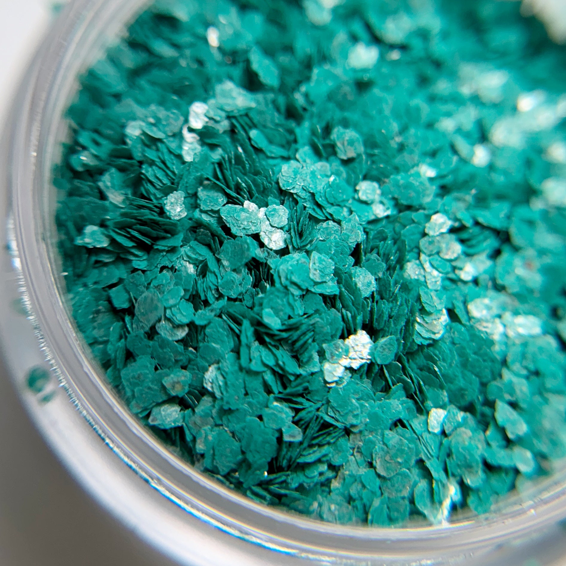Close-up of teal glitter in a clear container