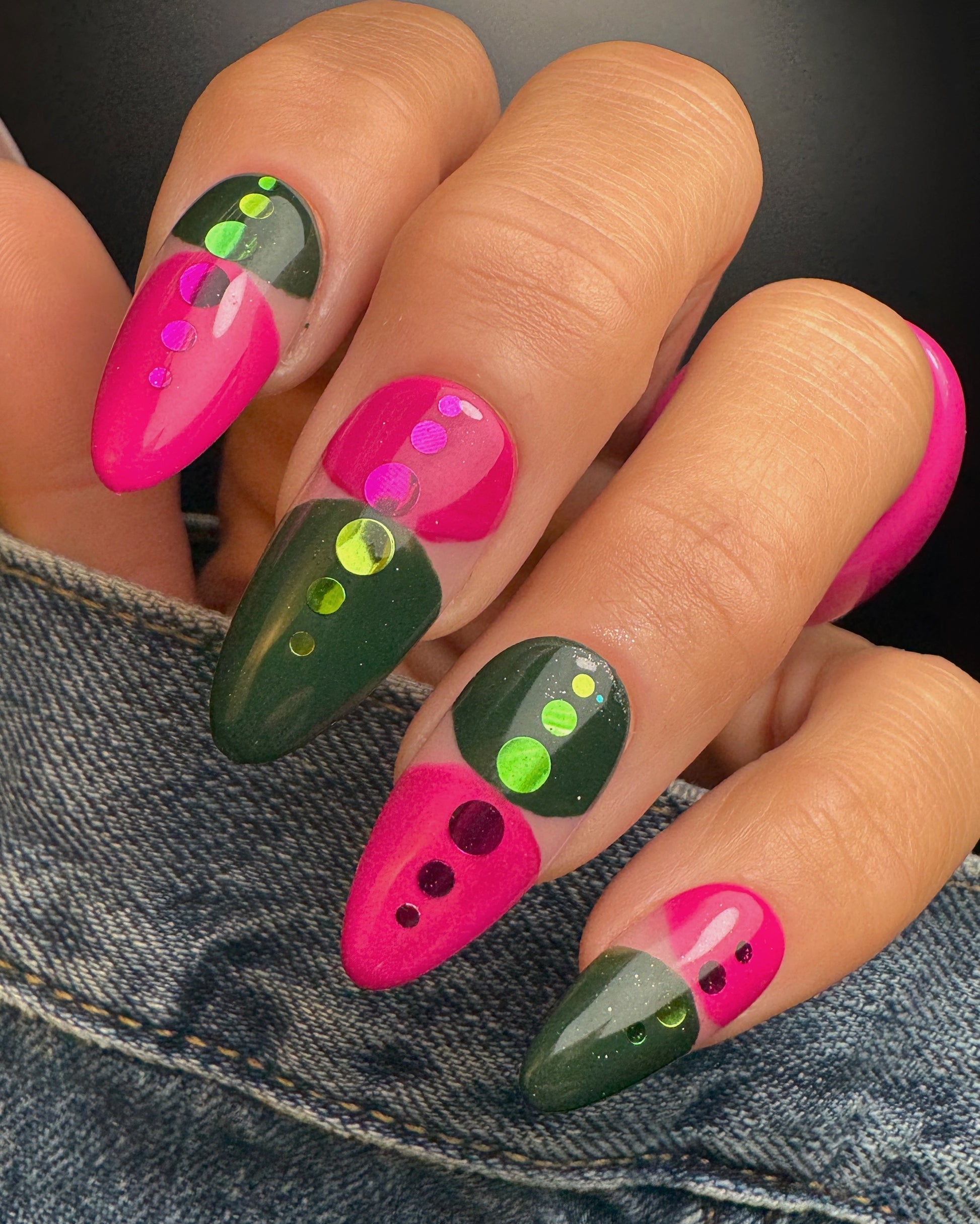 Nails with pink and green design on a denim background