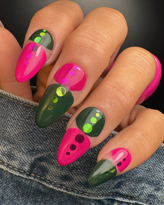 Nails with pink and green design on a denim background