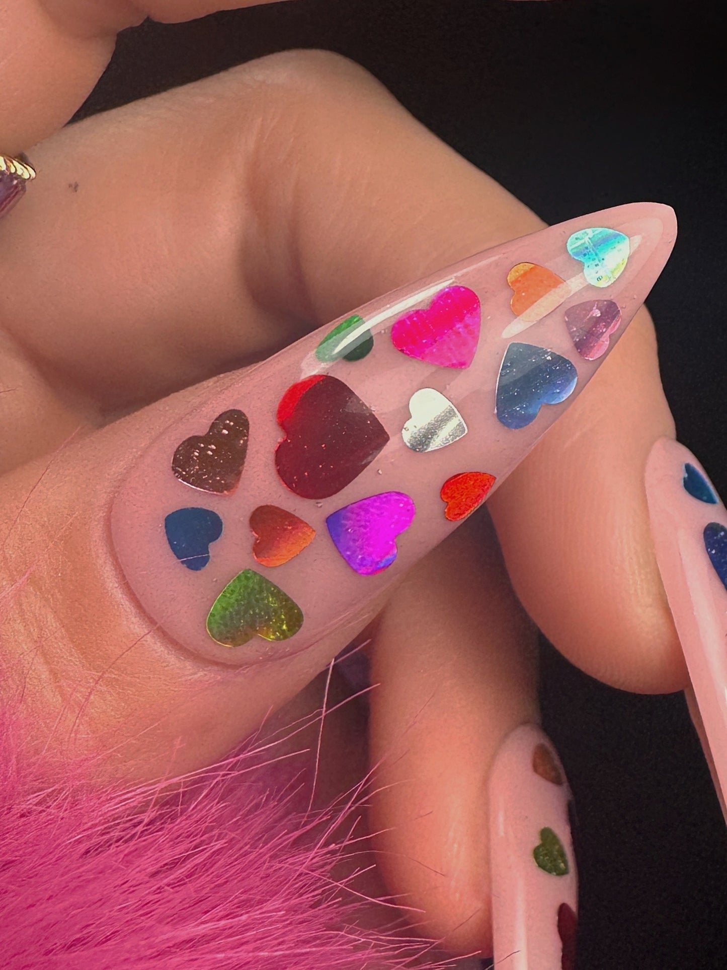 Nail art with colorful heart-shaped decorations on a clear background