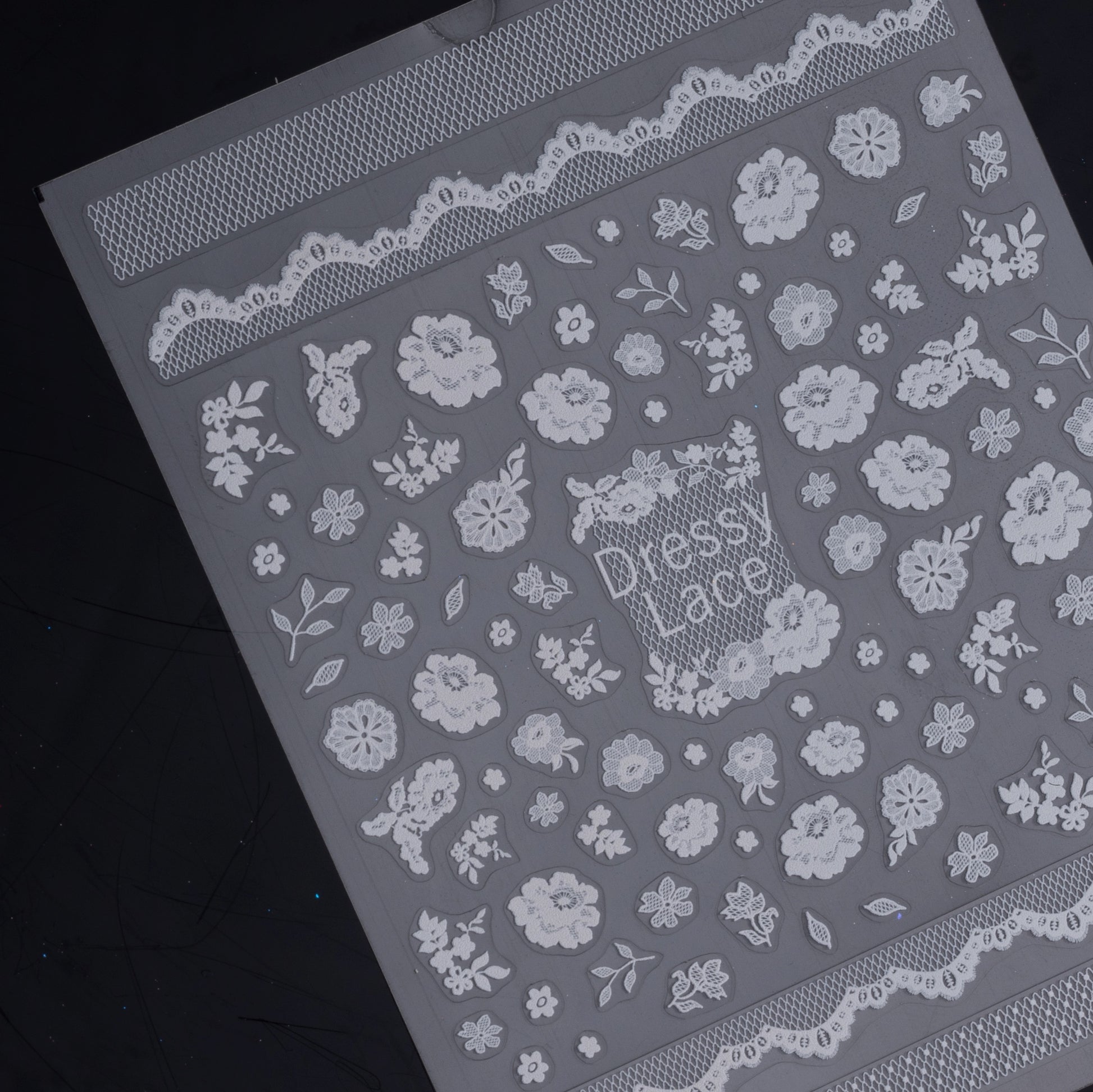 Detail view of nail decal sheet on dark background.