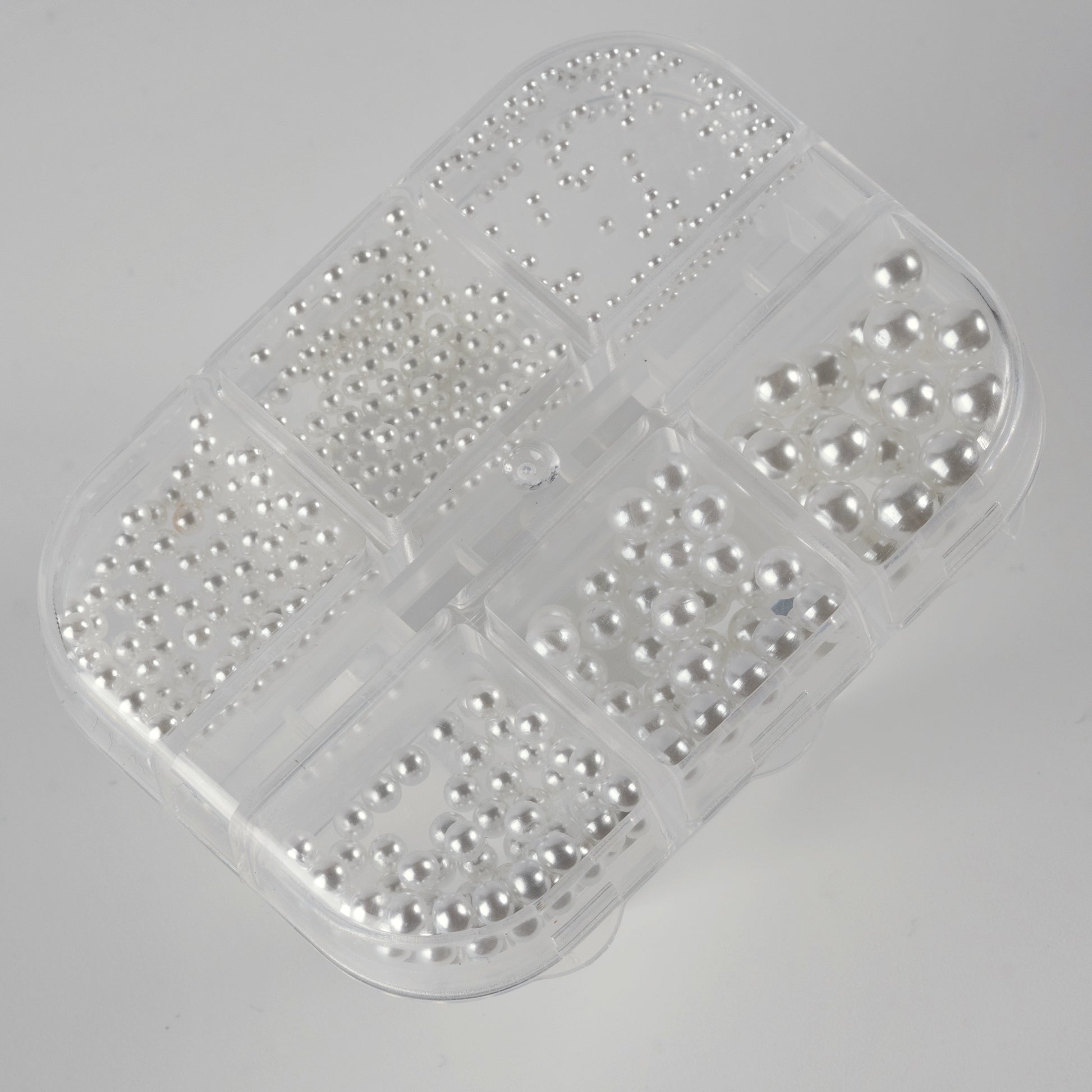 Clear case with white pearls on white background.