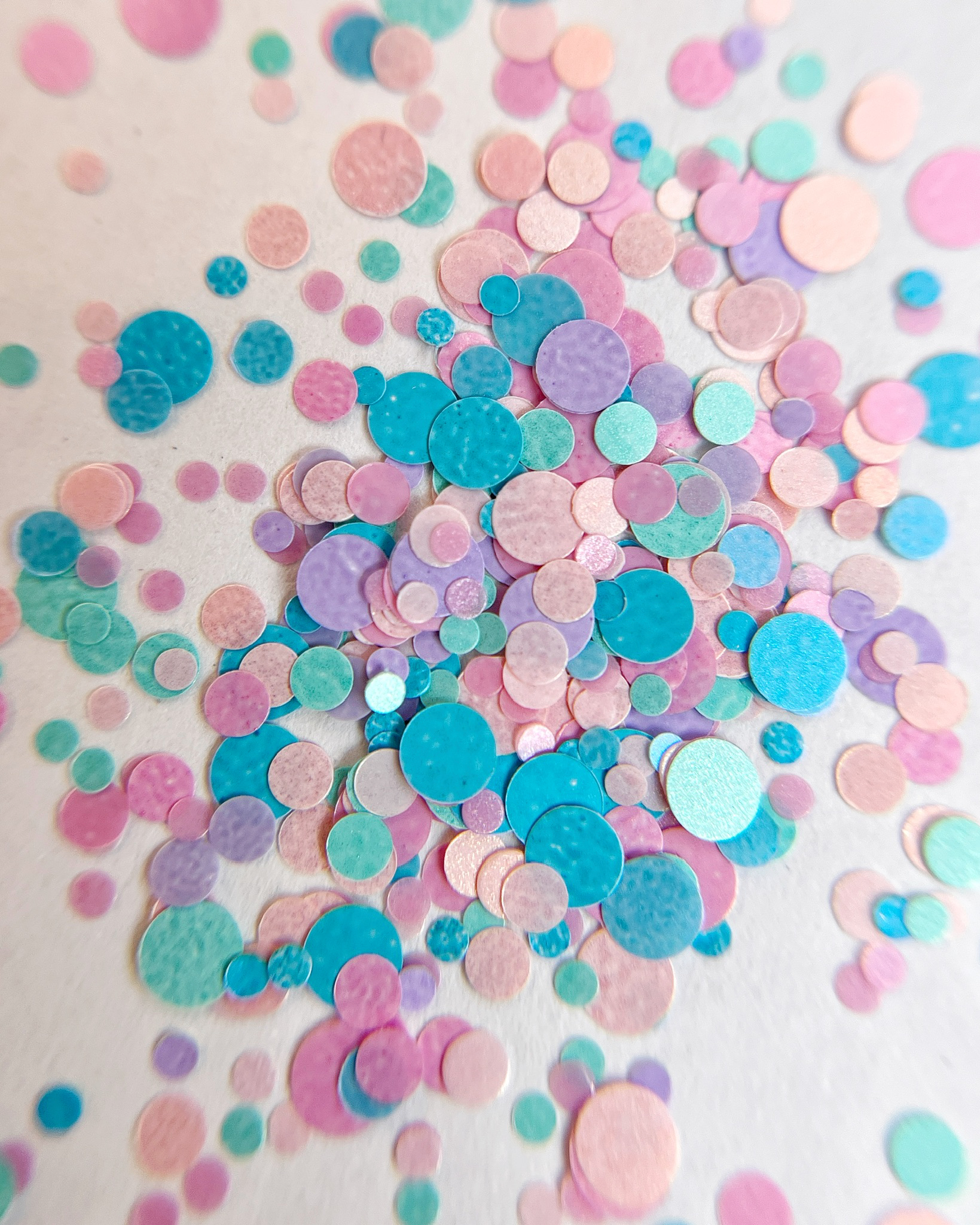 Pastel round glitter scattered on white background