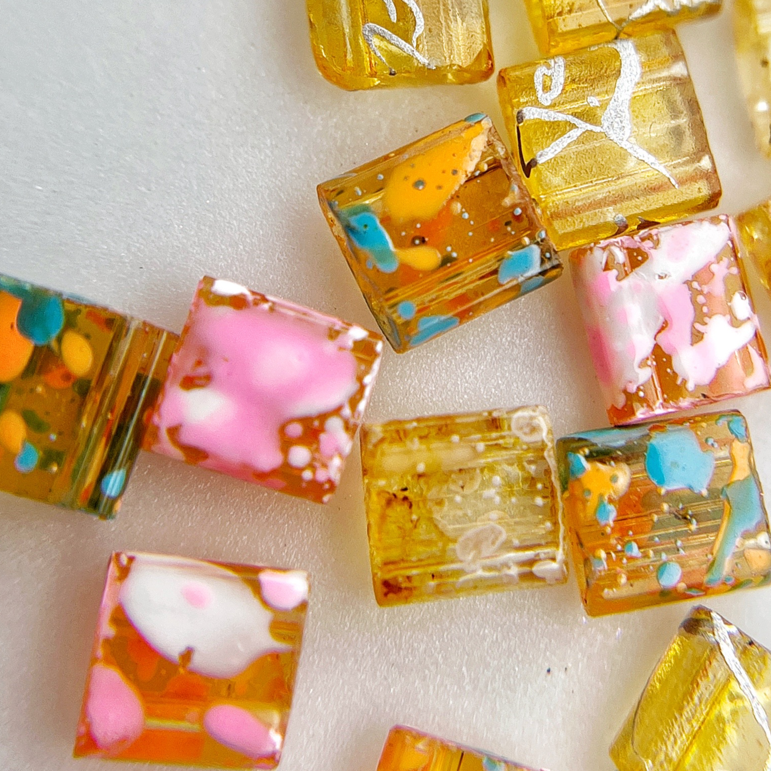 Multicolor square resin nail charms on white background. 