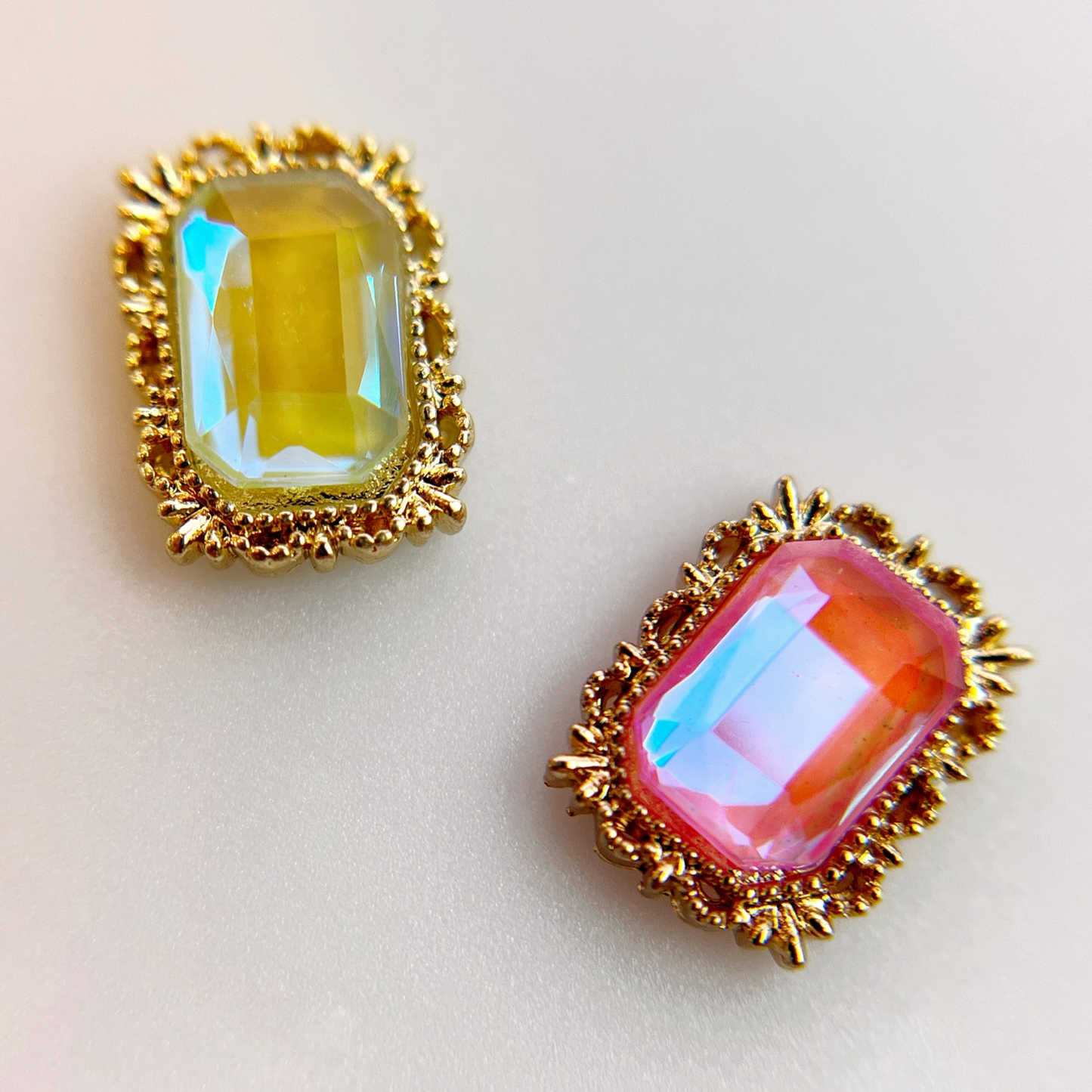 Rounded rectangle rhinestone sharm with gold frame on white background. 