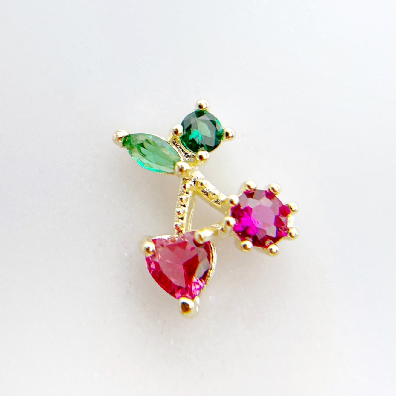 Rhinestone cherry charm on white background. 