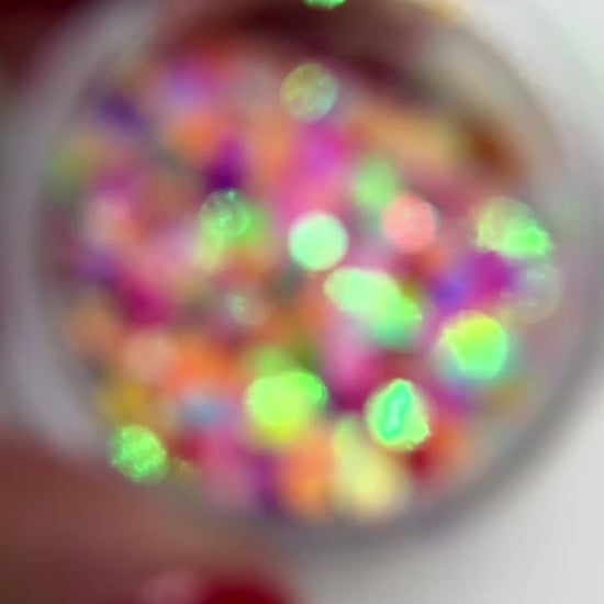 hand holding jar of multicolor glitter