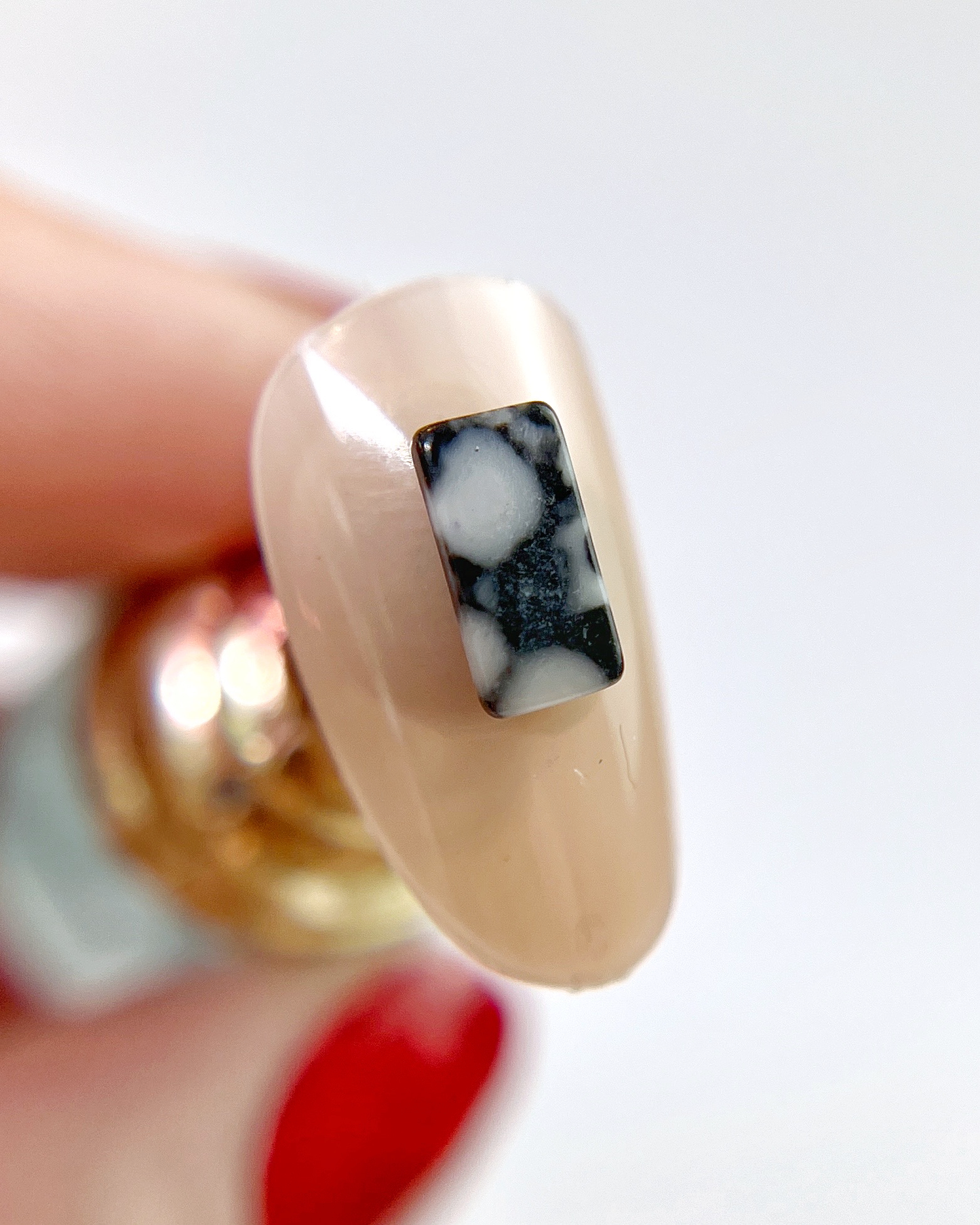 Hand holding decorated nail tip. 