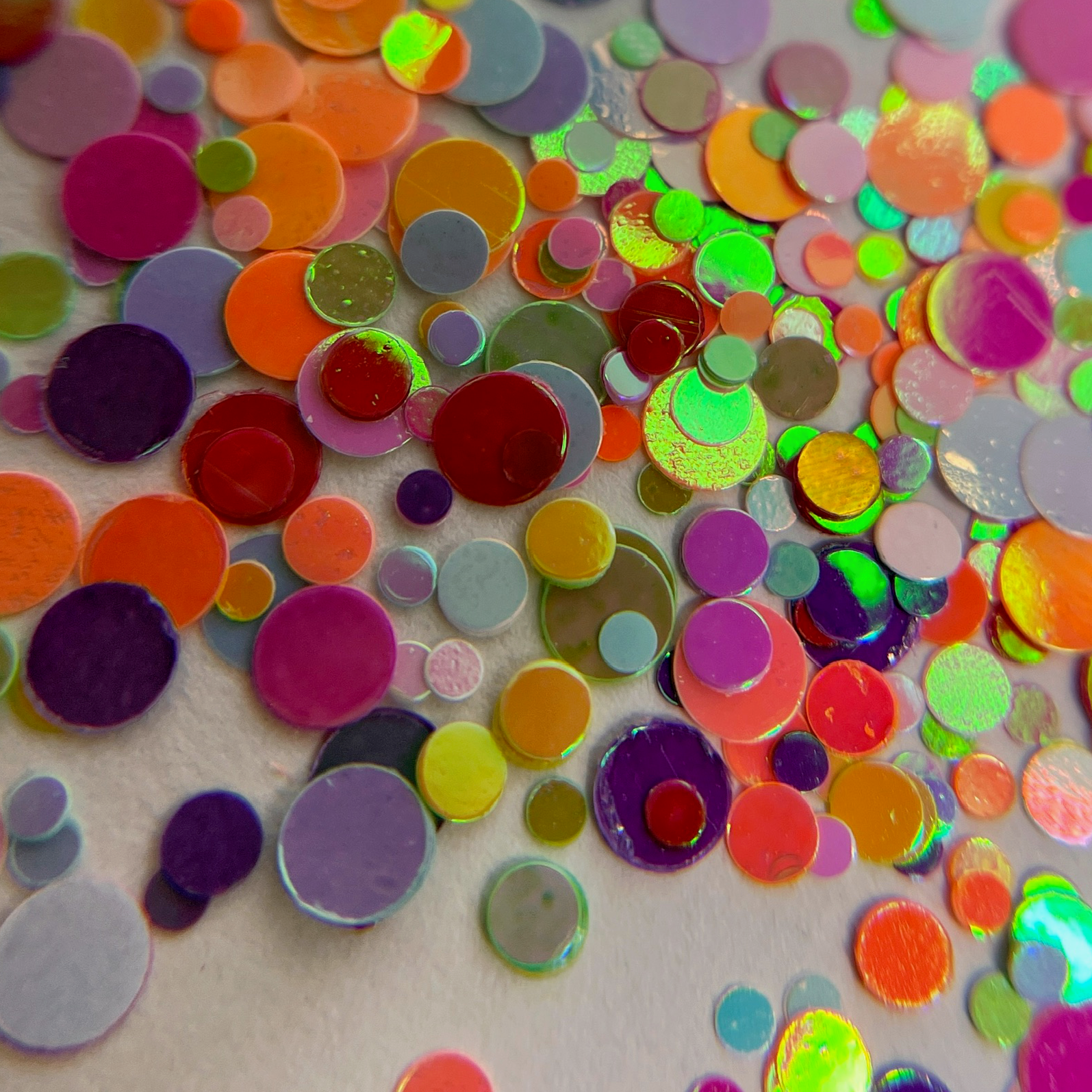 Multicolor spot glitter scattered on white background