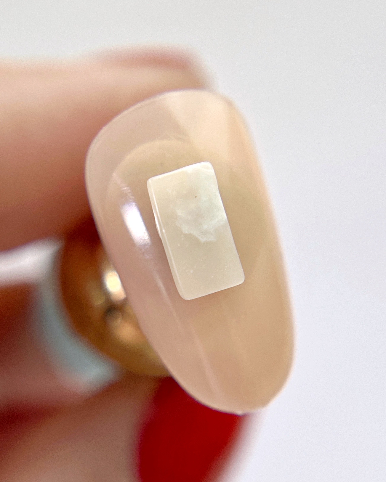 Hand holding decorated nail tip. 